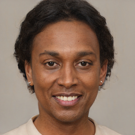 Joyful black adult female with short  black hair and brown eyes