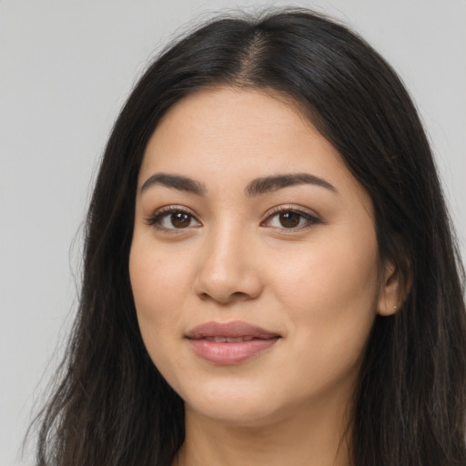 Joyful latino young-adult female with long  brown hair and brown eyes