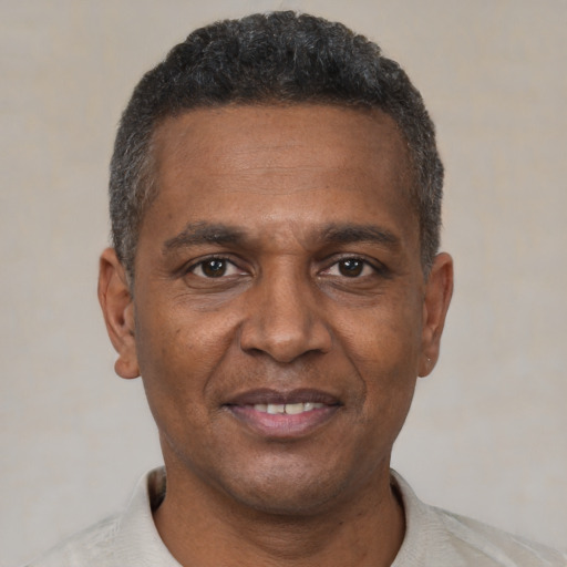 Joyful black adult male with short  brown hair and brown eyes