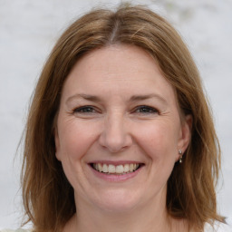 Joyful white adult female with medium  brown hair and grey eyes