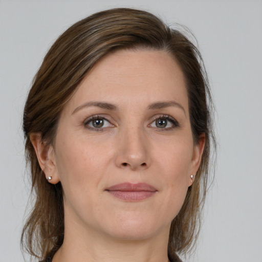 Joyful white young-adult female with medium  brown hair and grey eyes