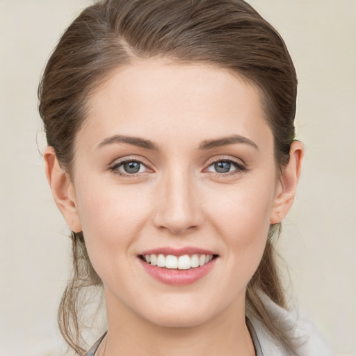 Joyful white young-adult female with medium  brown hair and grey eyes