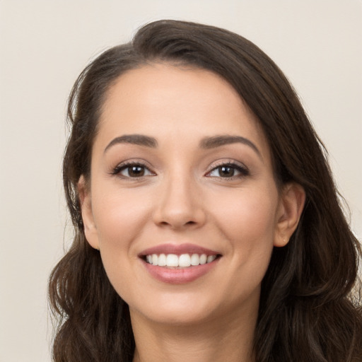 Joyful white young-adult female with long  brown hair and brown eyes