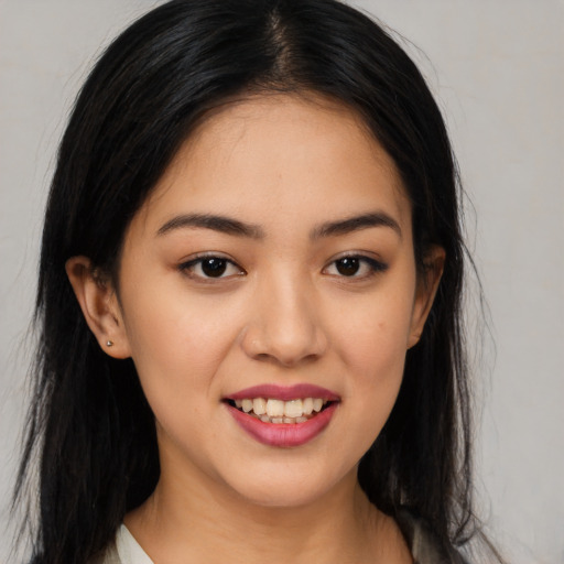Joyful latino young-adult female with long  brown hair and brown eyes