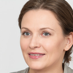 Joyful white adult female with medium  brown hair and grey eyes