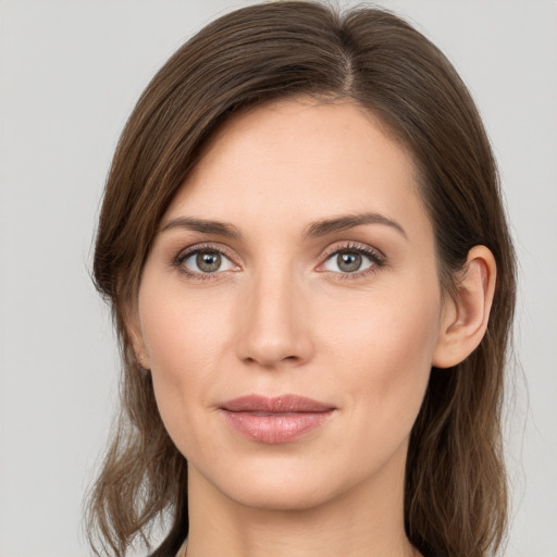 Joyful white young-adult female with medium  brown hair and grey eyes