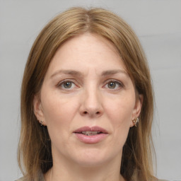 Joyful white adult female with medium  brown hair and grey eyes