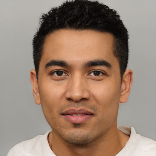 Joyful latino young-adult male with short  black hair and brown eyes