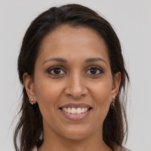Joyful latino young-adult female with medium  brown hair and brown eyes