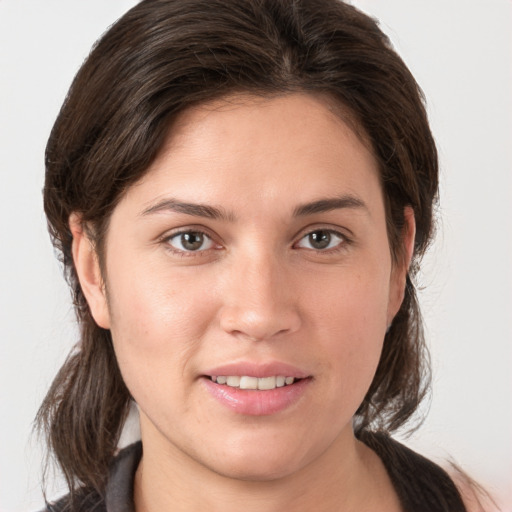 Joyful white young-adult female with medium  brown hair and grey eyes