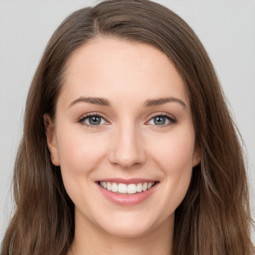 Joyful white young-adult female with long  brown hair and grey eyes