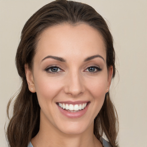 Joyful white young-adult female with long  brown hair and grey eyes