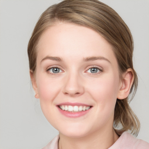 Joyful white young-adult female with medium  brown hair and blue eyes