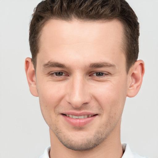 Joyful white young-adult male with short  brown hair and brown eyes