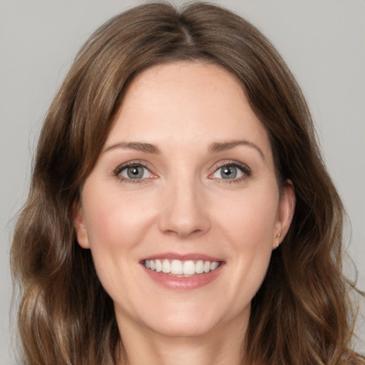 Joyful white young-adult female with medium  brown hair and green eyes