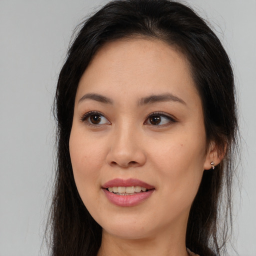 Joyful asian young-adult female with long  brown hair and brown eyes