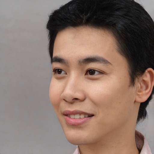Joyful asian young-adult male with short  black hair and brown eyes