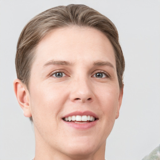 Joyful white young-adult female with short  brown hair and grey eyes