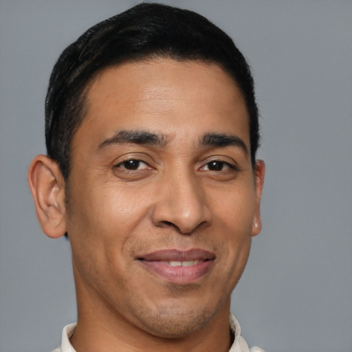 Joyful latino young-adult male with short  brown hair and brown eyes
