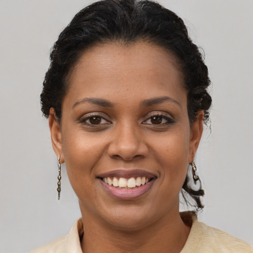 Joyful black young-adult female with short  brown hair and brown eyes