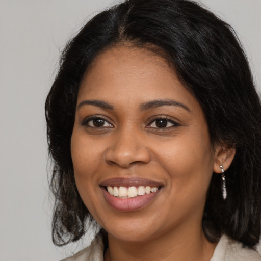 Joyful black young-adult female with long  brown hair and brown eyes