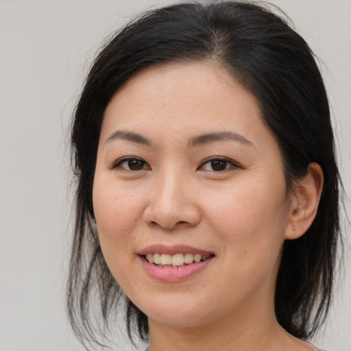 Joyful asian young-adult female with medium  brown hair and brown eyes