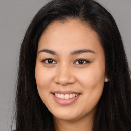 Joyful asian young-adult female with long  brown hair and brown eyes