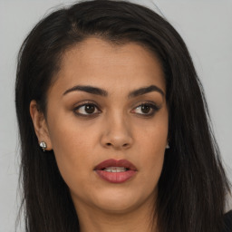 Joyful latino young-adult female with long  brown hair and brown eyes