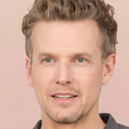 Joyful white adult male with short  brown hair and grey eyes