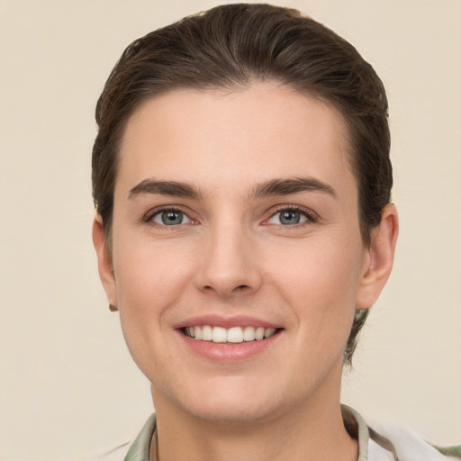 Joyful white young-adult female with short  brown hair and grey eyes