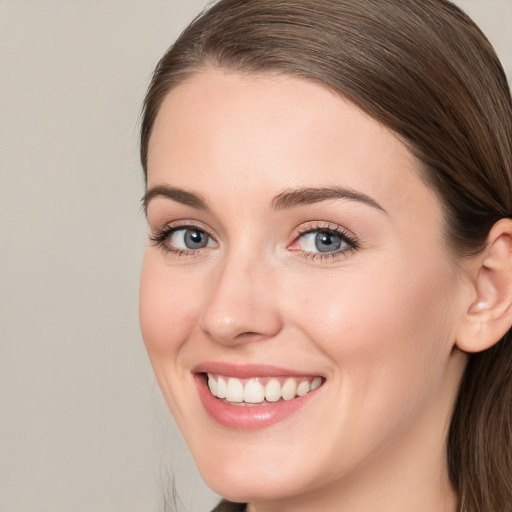 Joyful white young-adult female with long  brown hair and grey eyes