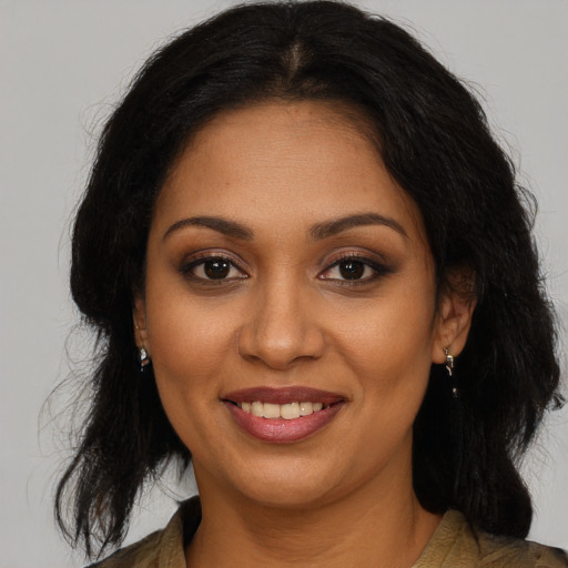Joyful black young-adult female with long  brown hair and brown eyes