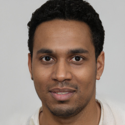 Joyful black young-adult male with short  black hair and brown eyes