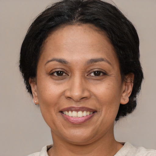 Joyful latino adult female with medium  brown hair and brown eyes