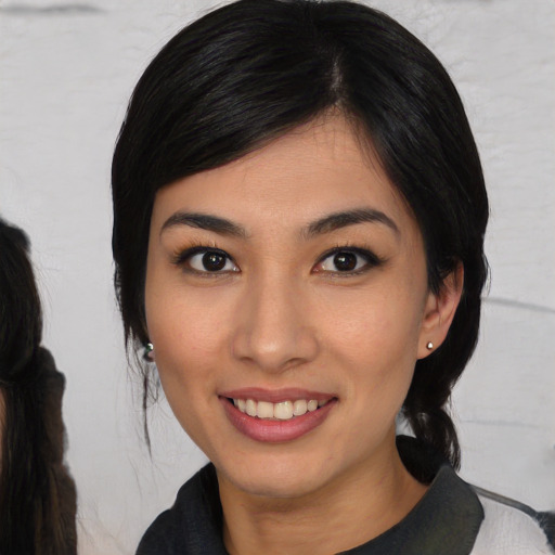 Joyful asian young-adult female with medium  black hair and brown eyes