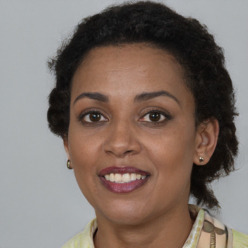 Joyful latino adult female with short  brown hair and brown eyes