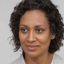 Joyful black adult female with medium  brown hair and brown eyes