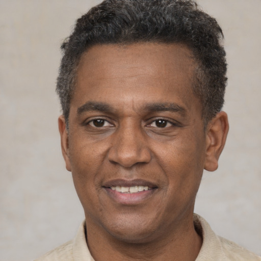 Joyful black adult male with short  brown hair and brown eyes
