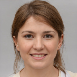 Joyful white young-adult female with medium  brown hair and grey eyes