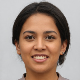 Joyful latino young-adult female with medium  brown hair and brown eyes