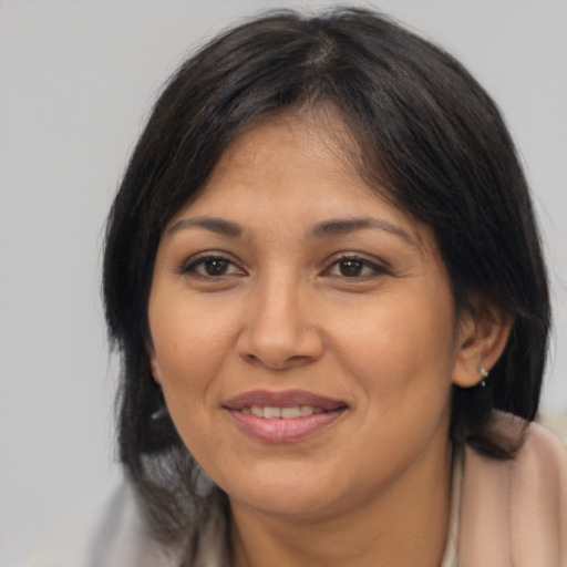 Joyful latino adult female with medium  brown hair and brown eyes
