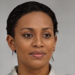 Joyful black adult female with medium  brown hair and brown eyes