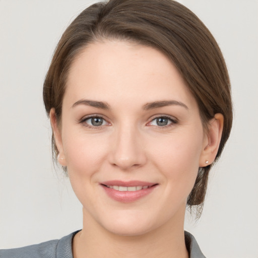 Joyful white young-adult female with medium  brown hair and grey eyes