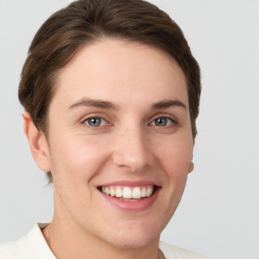 Joyful white young-adult female with short  brown hair and grey eyes