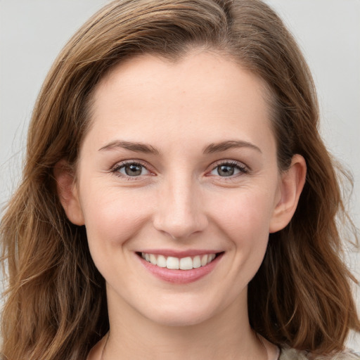 Joyful white young-adult female with long  brown hair and grey eyes