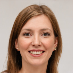 Joyful white young-adult female with long  brown hair and green eyes