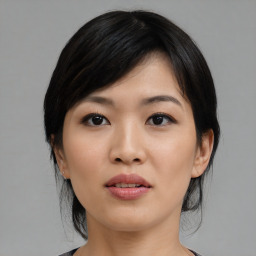 Joyful asian young-adult female with medium  black hair and brown eyes