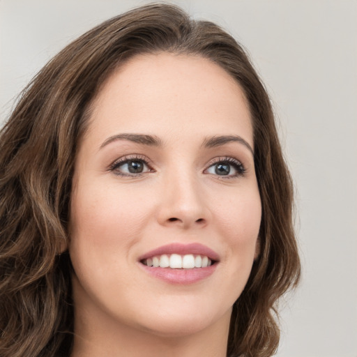 Joyful white young-adult female with long  brown hair and green eyes