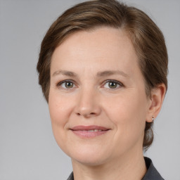 Joyful white adult female with medium  brown hair and grey eyes