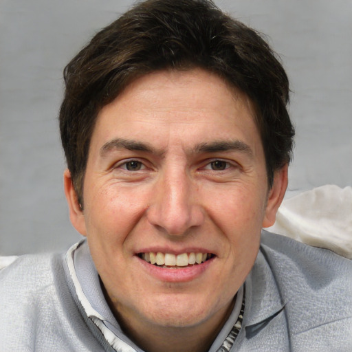 Joyful white adult male with short  brown hair and grey eyes